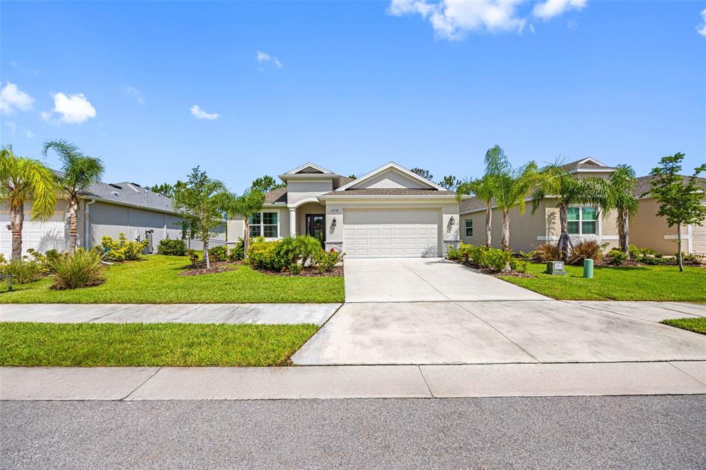 12739 Rainwashed Loop Parrish, FL 34219 - Photo 5 of 45 a front view of a house with a yard and potted plants
