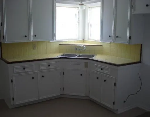 a room with granite countertop cabinets and window