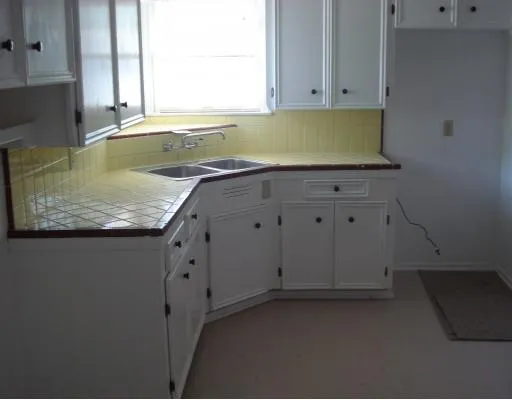 a kitchen with white cabinets and a sink