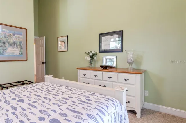 a bedroom with a bed and a lamp on dresser