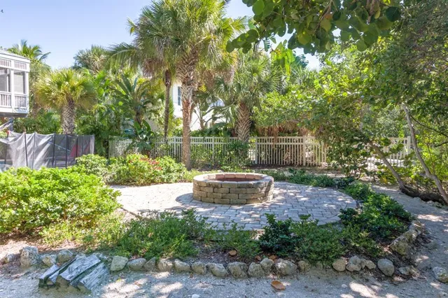 a view of a backyard with fountain plants and large tree