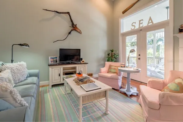 a living room with furniture a flat screen tv and a window