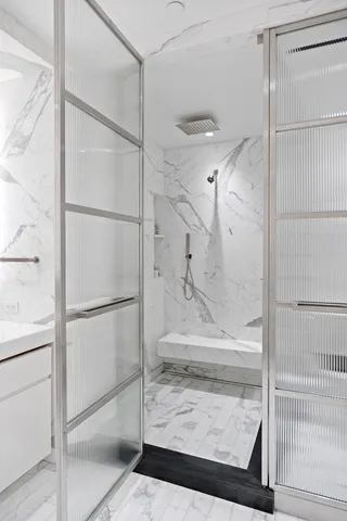 a bathroom with a double vanity sink large mirror and a bathtub