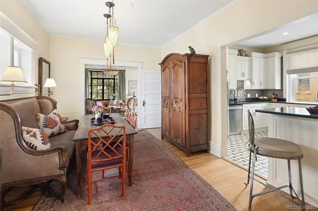 a very nice looking dining room with kitchen island stainless steel appliances furniture a window and kitchen view