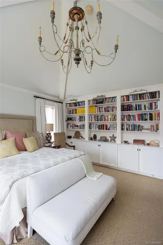 a bedroom with a large bed and a chandelier