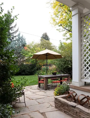 a view of a deck with furniture and a garden
