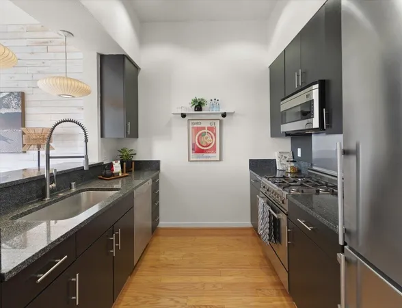 a kitchen with stainless steel appliances granite countertop a sink stove and refrigerator