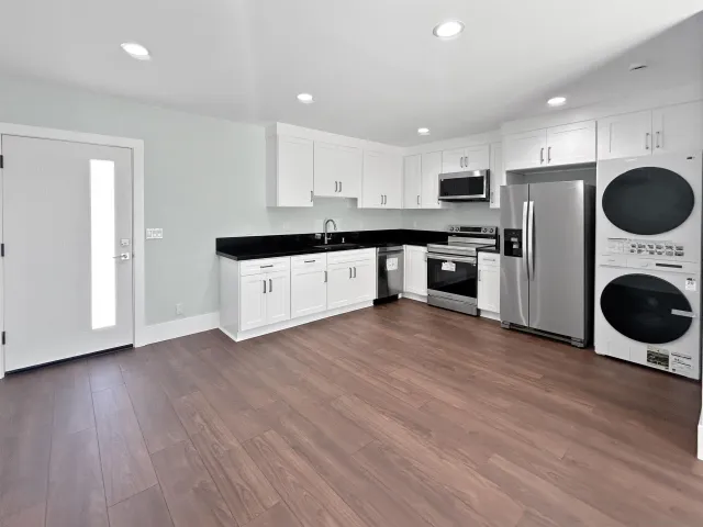 a kitchen with granite countertop a white stove top oven and refrigerator