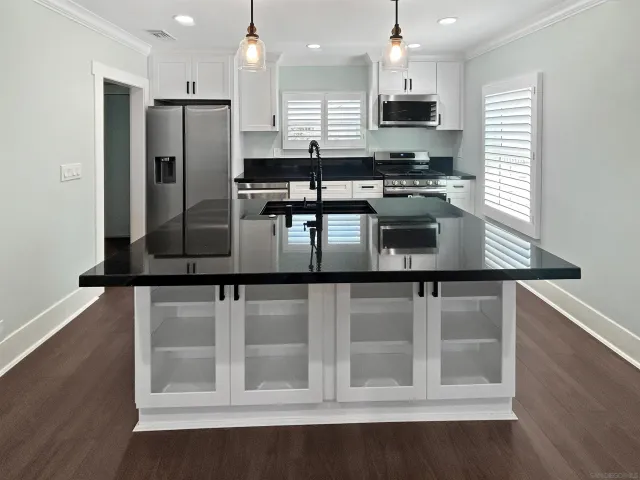 a kitchen with stainless steel appliances granite countertop a stove a refrigerator and a microwave