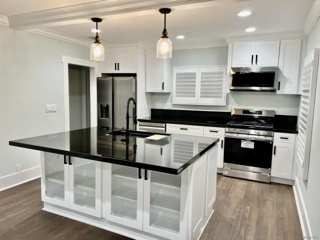 a kitchen with stainless steel appliances granite countertop a sink stove and refrigerator