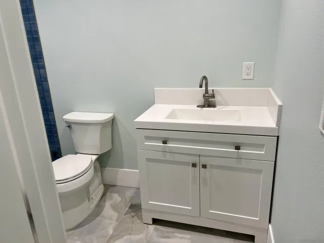 a bathroom with a sink a toilet and a mirror