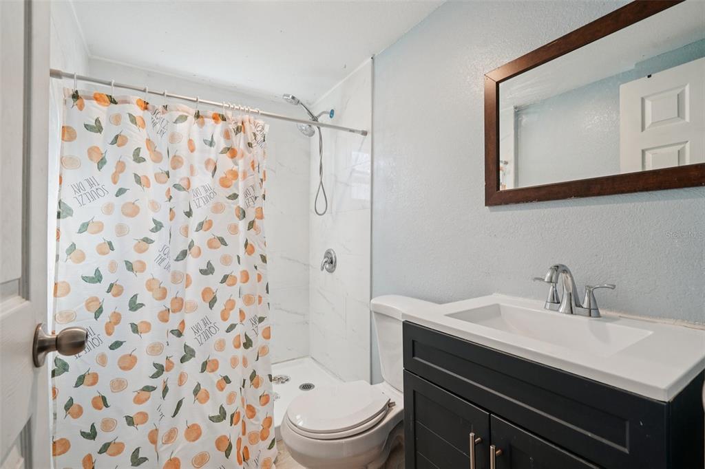 2432 Northwest 2nd Street Ocala, FL 34475 - Photo 21 of 29 a bathroom with a sink toilet a mirror and shower curtain