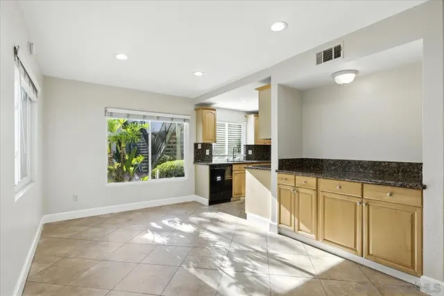 a view of a kitchen with a sink and dishwasher a stove top oven with wooden floor