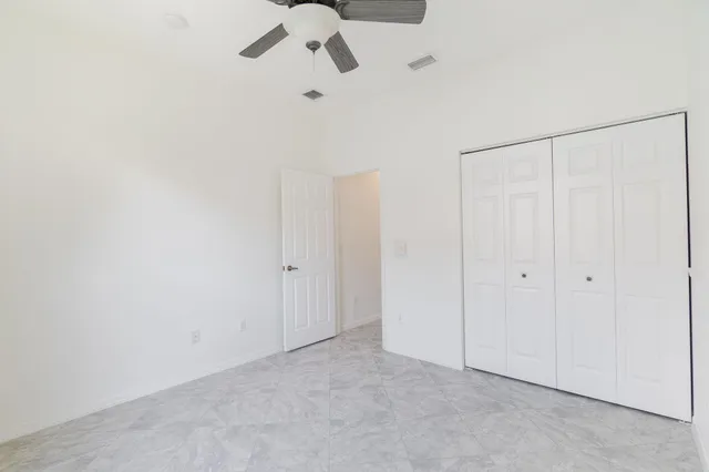 a front view of multi story residential apartment building with yard and sign board