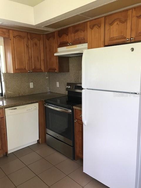 25385 Sandhill Boulevard, Unit E1 Punta Gorda, FL 33983 - Photo 3 of 16 a kitchen with a refrigerator and a stove