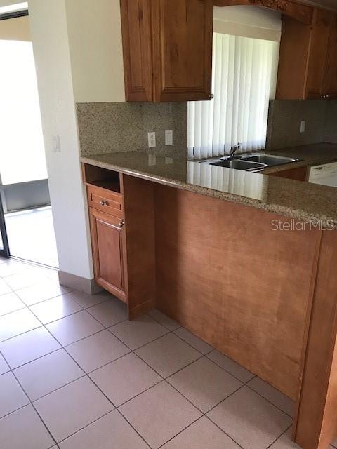 25385 Sandhill Boulevard, Unit E1 Punta Gorda, FL 33983 - Photo 4 of 16 a kitchen with granite countertop a sink and a stove