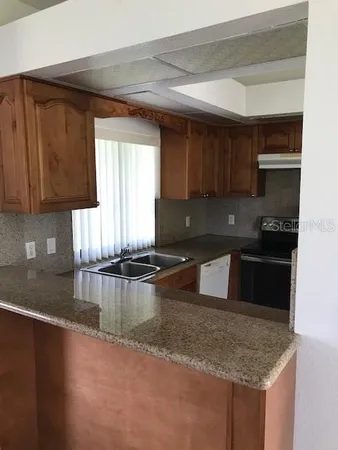 a kitchen with a refrigerator a stove a sink and a counter top space