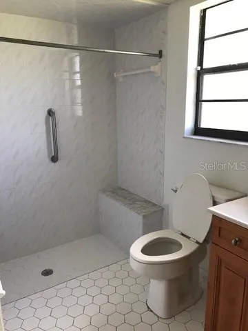 a white toilet sitting next to a shower