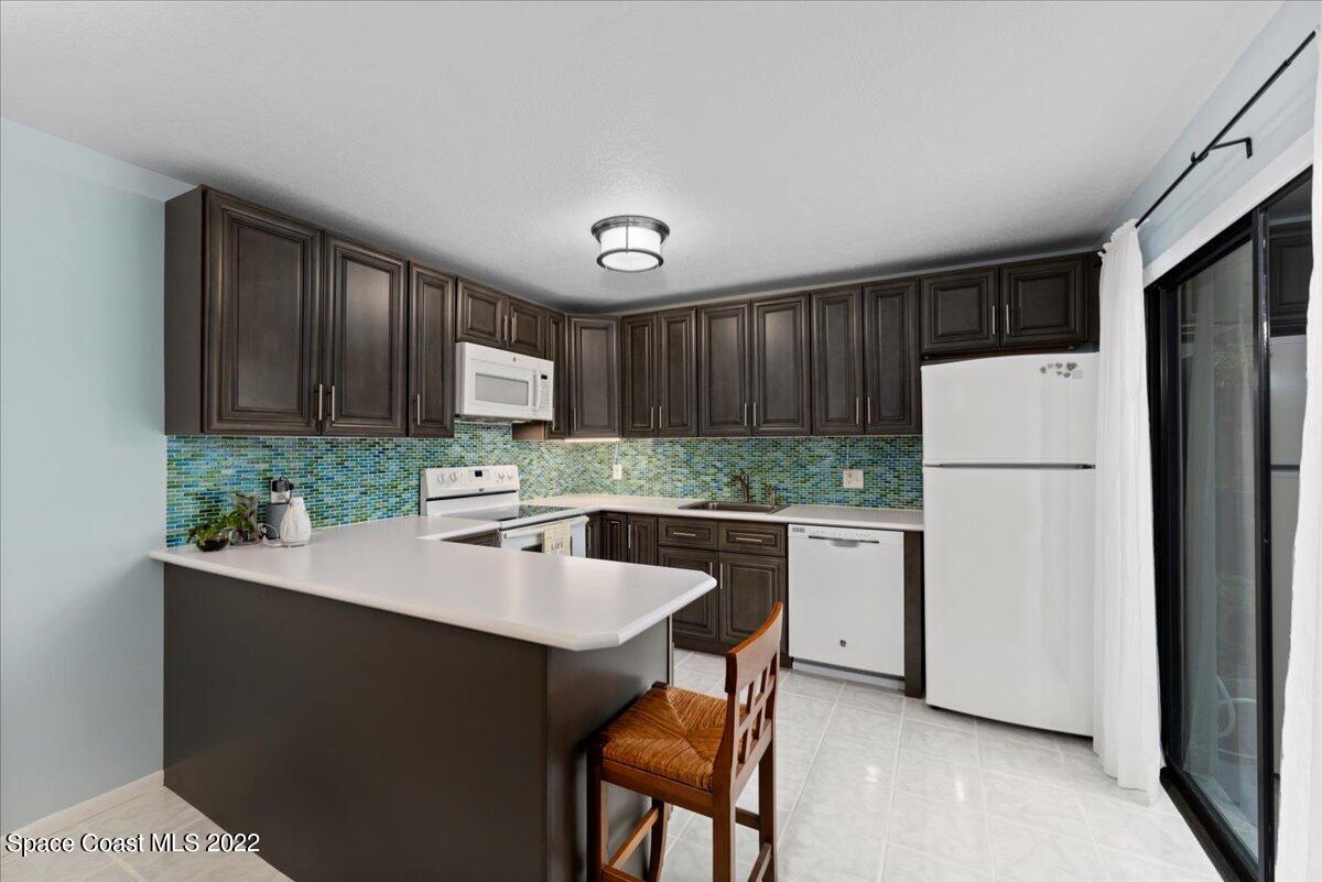 2012 Dan Court Palm Bay, FL 32905 - Photo 12 of 22 a kitchen with wooden cabinets and white appliances
