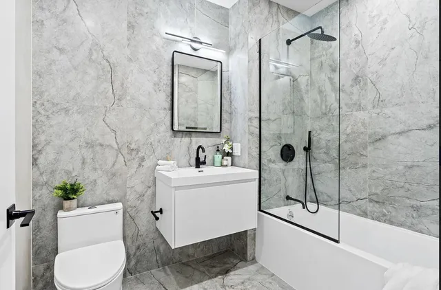 a bathroom with a sink a toilet and shower