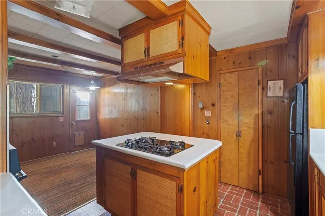 a kitchen that has a kitchen island wooden cabinets and stainless steel appliances