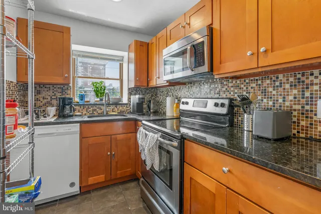 a kitchen with stainless steel appliances granite countertop a sink stove and cabinets
