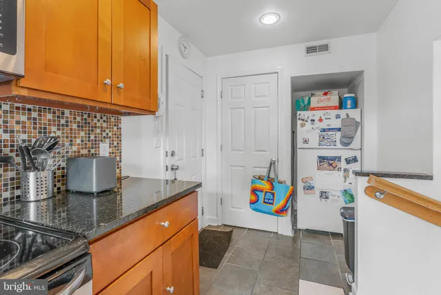a kitchen with stainless steel appliances granite countertop a sink and a refrigerator