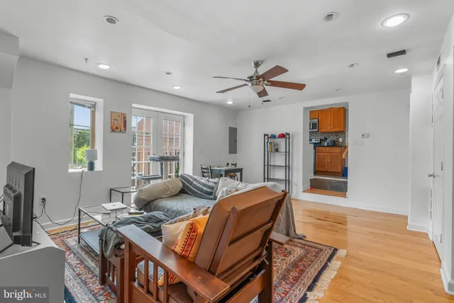 a living room with furniture a ceiling fan and a window