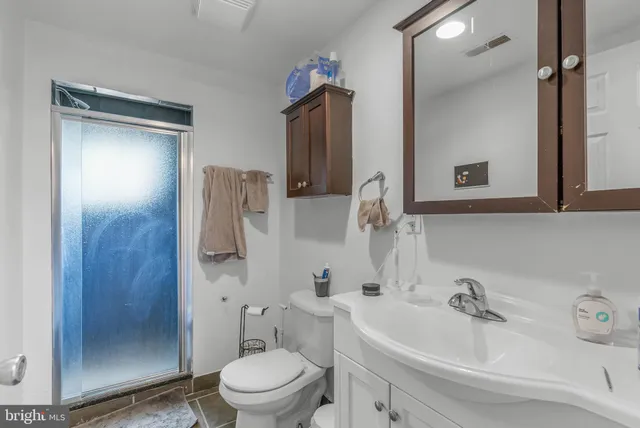 a bathroom with a sink a toilet and shower