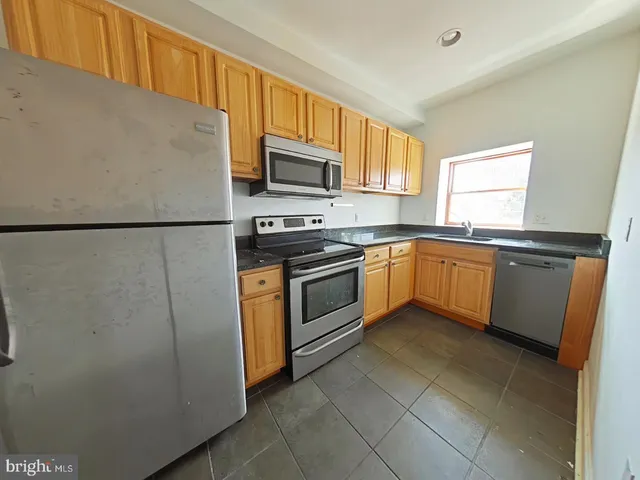 a kitchen with stainless steel appliances granite countertop white refrigerator sink and stove