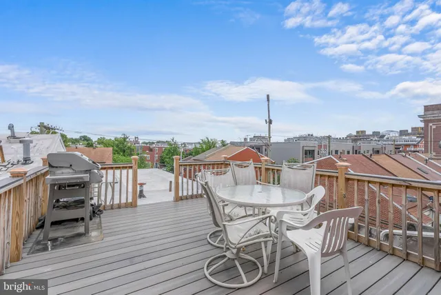 a view of a roof deck with table and chairs