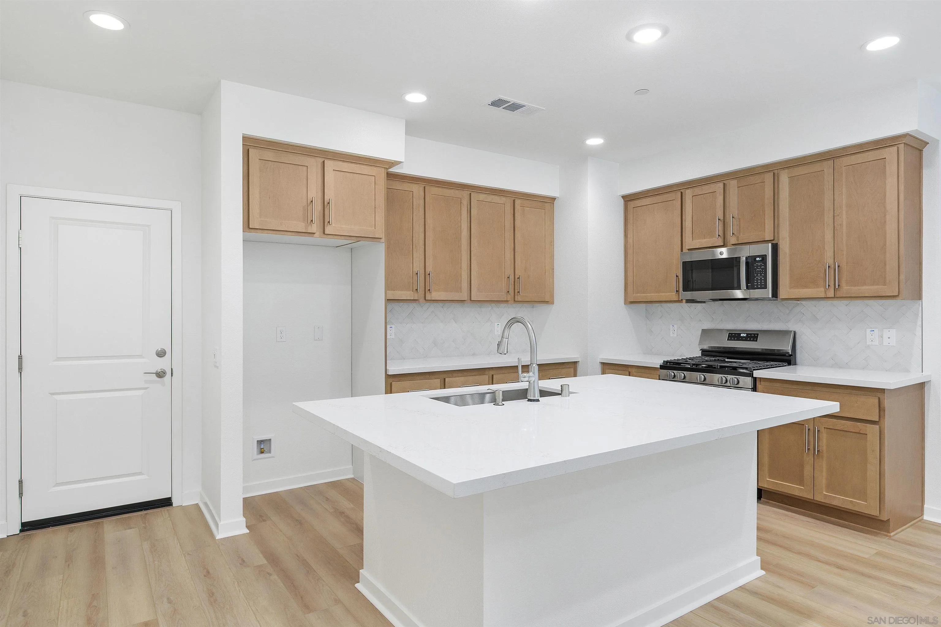 32336 Brunello Way Temecula, CA 92591 - Photo 2 of 26 a kitchen with a sink a stove a refrigerator cabinets and a wooden floor