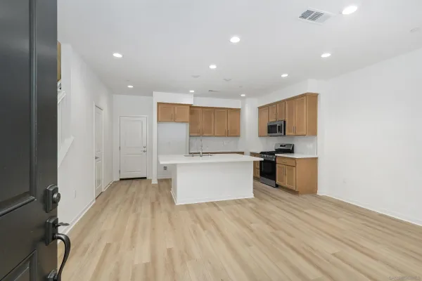 a large kitchen with a lot of counter space and stainless steel appliances