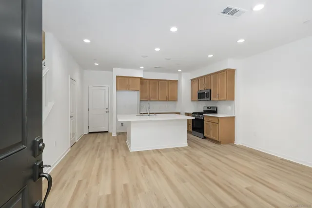 a large kitchen with a lot of counter space and stainless steel appliances
