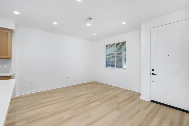 an empty room with wooden floor and windows