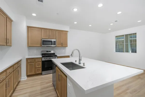 a kitchen with a sink a stove top oven and wooden floor