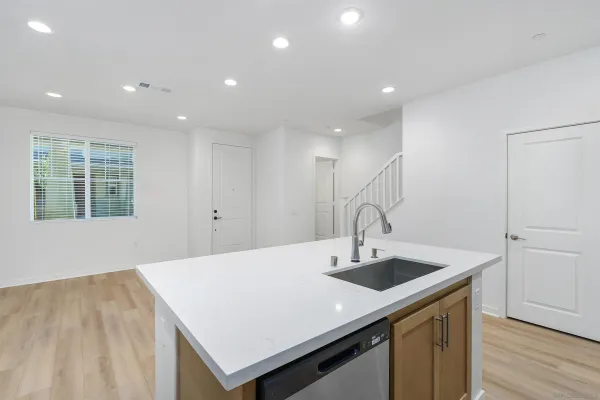 a kitchen with kitchen island a sink appliances and a window