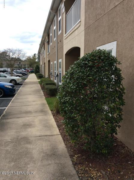 7920 Merrill Road, Unit 1009 Jacksonville, FL 32277 - Photo 20 of 22 a view of a street with plants and trees