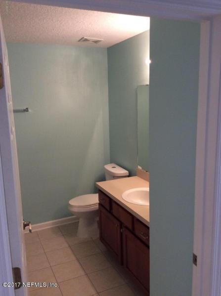 7920 Merrill Road, Unit 1009 Jacksonville, FL 32277 - Photo 9 of 22 a bathroom with a toilet a sink and mirror