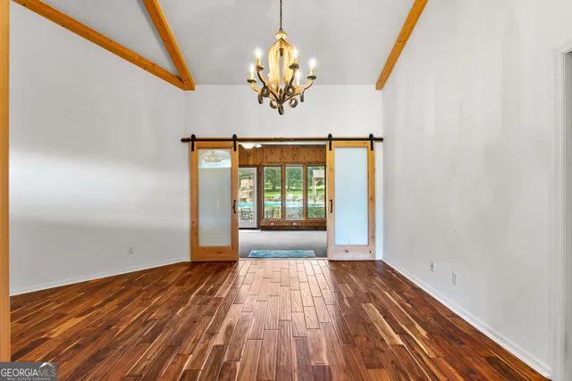 a view of a livingroom with a large window and wooden floor