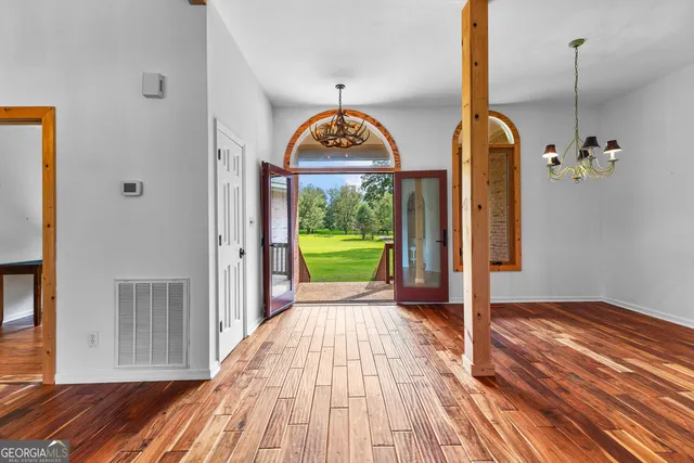 a view of empty room with wooden floor and windows