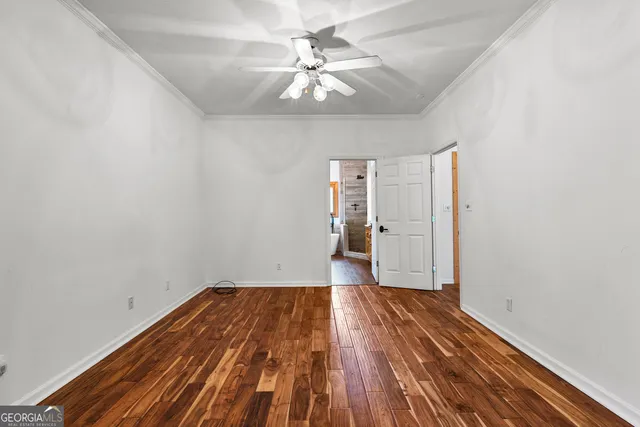 a view of an empty room with wooden floor fireplace and a window