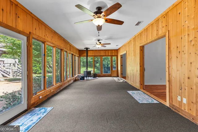 an empty room with windows and fan