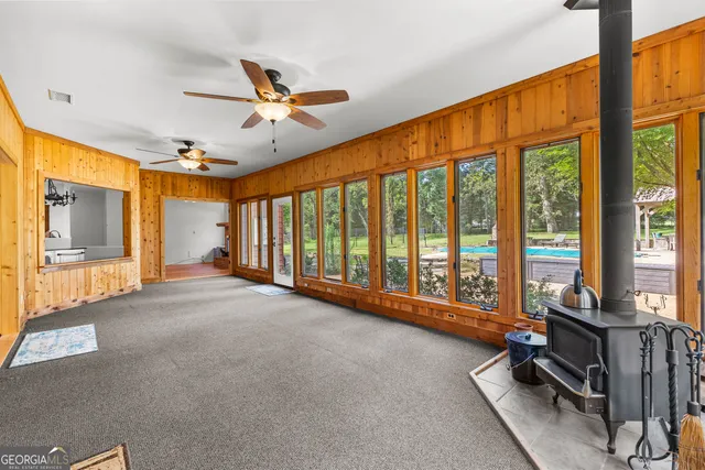an empty room with chandelier fan and window