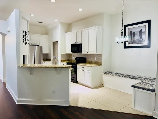 a kitchen with a refrigerator and a stove top oven