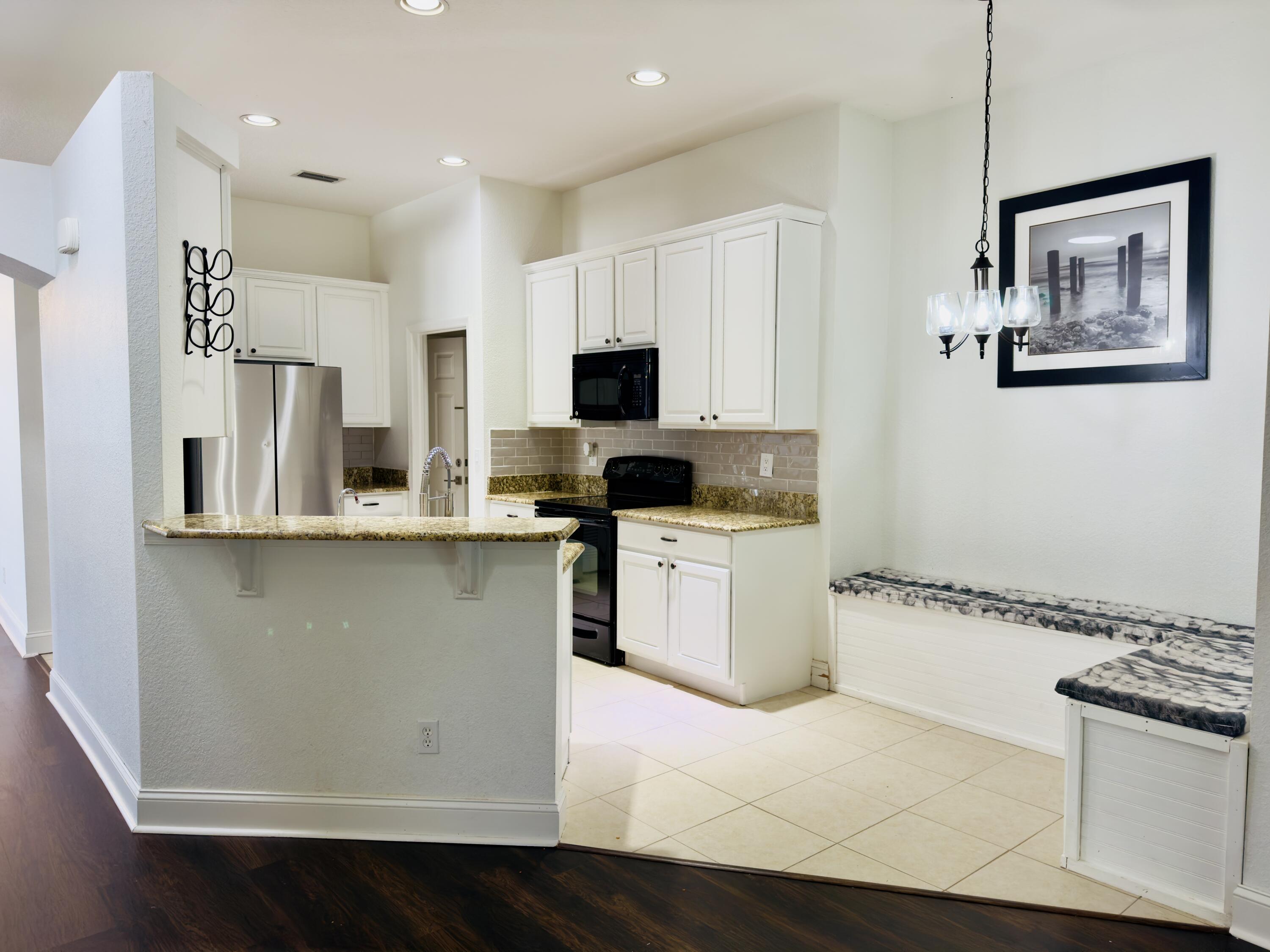 11479 Southwest Glengarry Court Port St. Lucie, FL 34987 - Photo 12 of 24 a kitchen with a refrigerator and a stove top oven