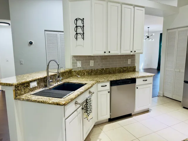 a kitchen with granite countertop a sink stove and refrigerator