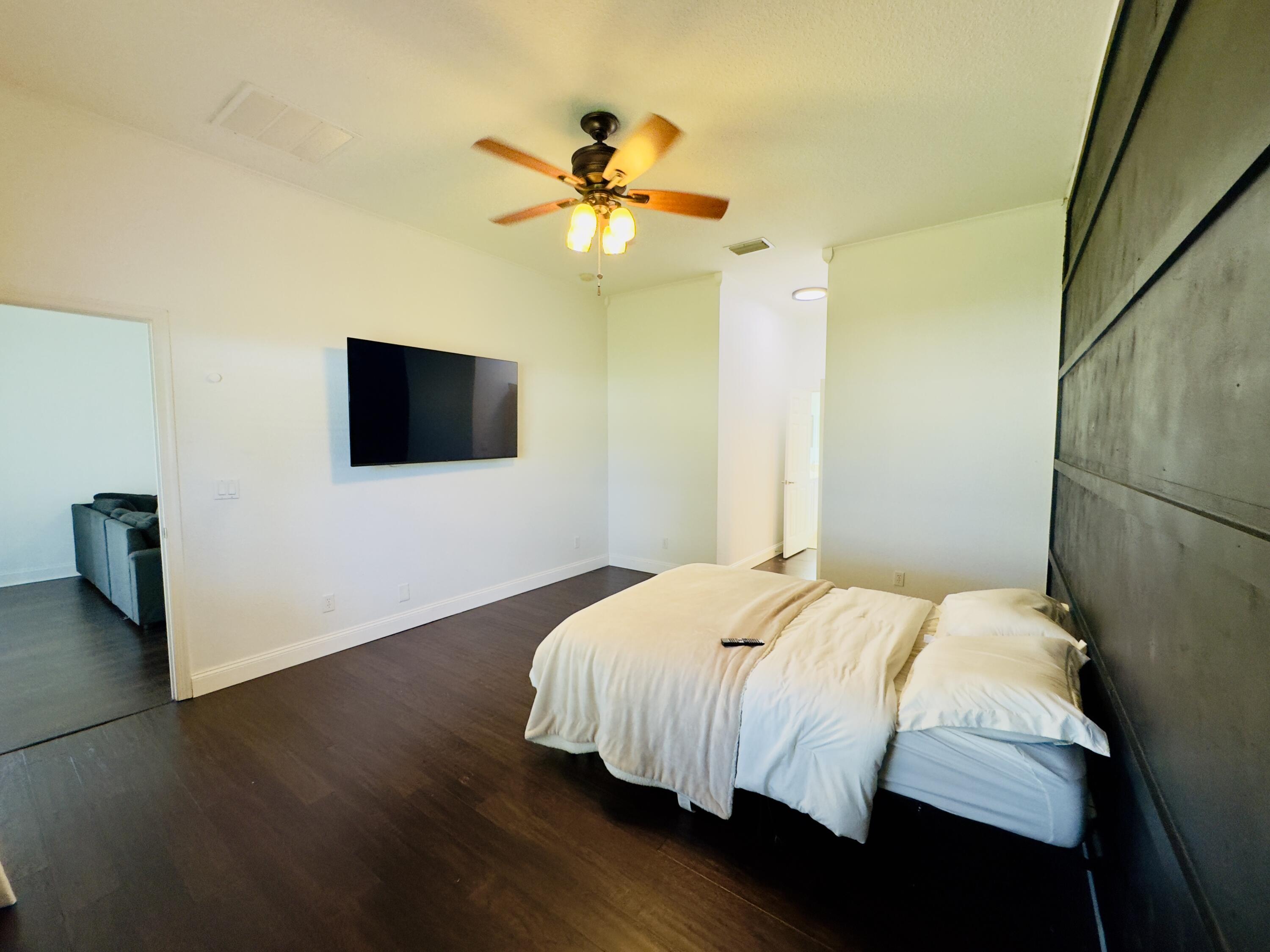 11479 Southwest Glengarry Court Port St. Lucie, FL 34987 - Photo 16 of 24 a bedroom with a bed and a flat screen tv