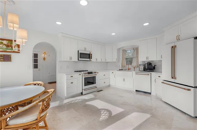 a kitchen with white cabinets and appliances