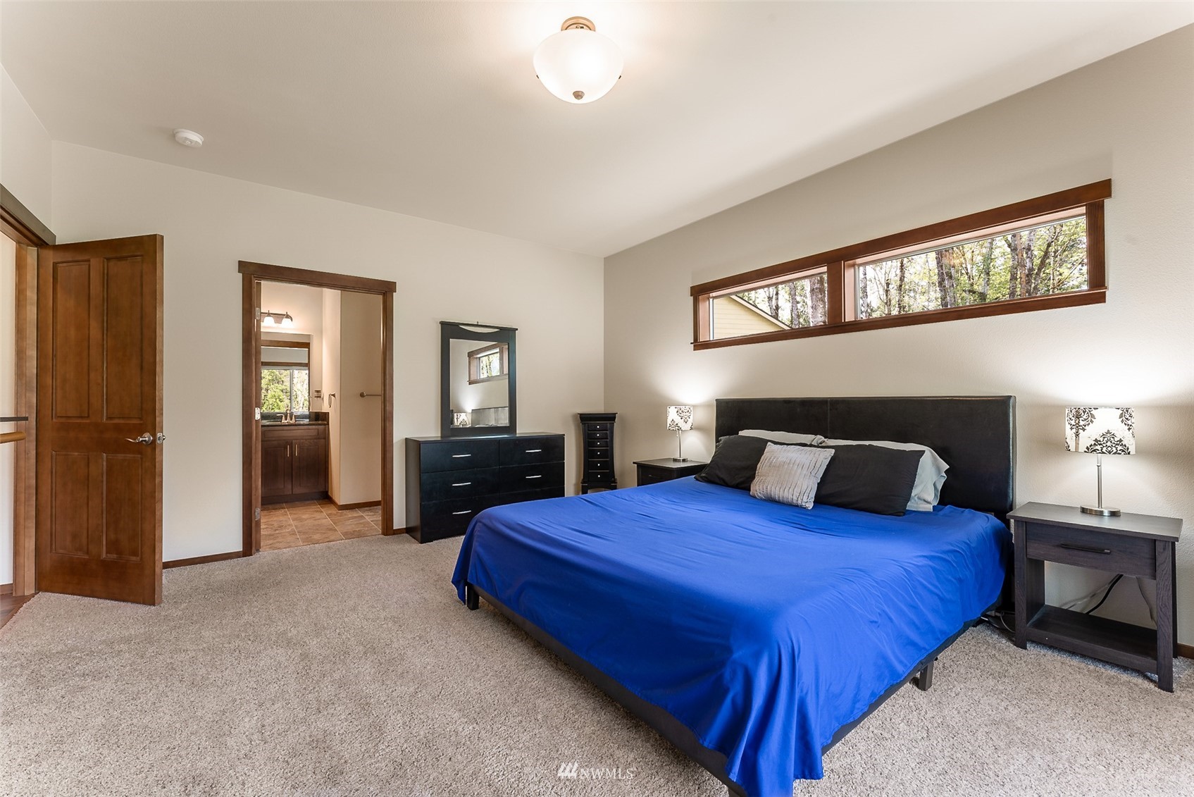 81 East Lighthouse Road Shelton, WA 98584 - Photo 12 of 28 a bedroom with a bed and a chandelier